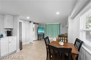 Dining room with a barn door, light flooring, and recessed lighting