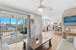 Living room with wood finished floors, plenty of natural light, and ceiling fan
