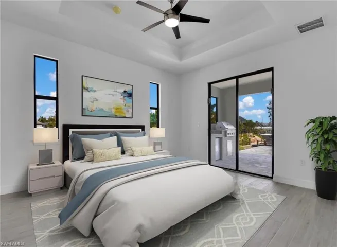 Bedroom with light hardwood / wood-style floors, access to exterior, multiple windows, and ceiling fan