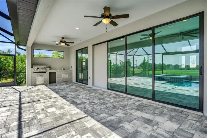 View of patio / terrace with ceiling fan, grilling area, a lanai, area for grilling, and sink