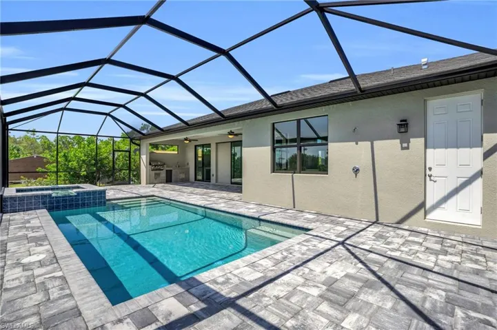 View of pool featuring an in ground hot tub, ceiling fan, a patio area, and a lanai