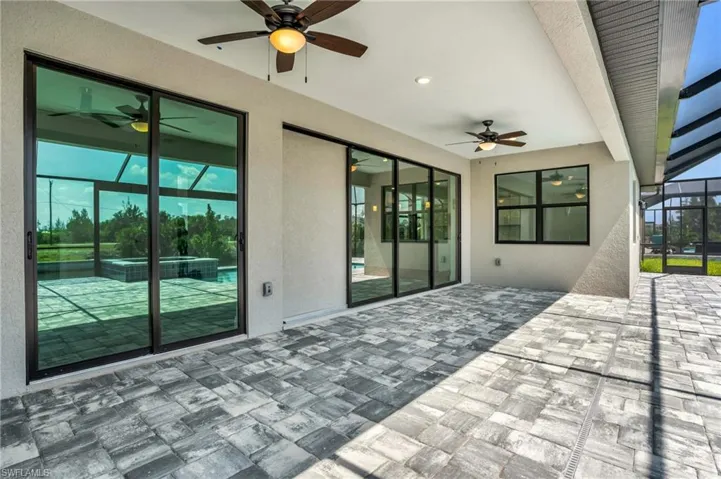 View of patio / terrace featuring glass enclosure and ceiling fan