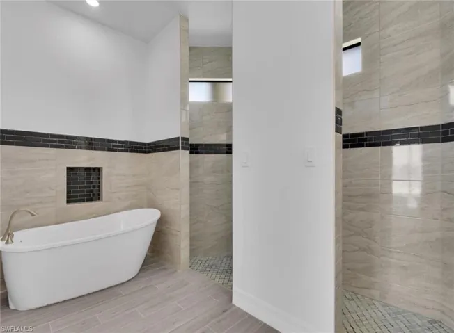 Bathroom with tile walls and independent shower and bath