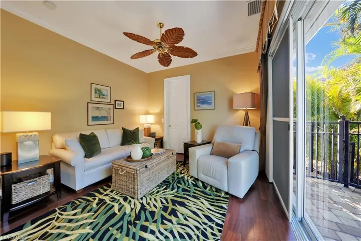 Living room with dark hardwood / wood-style floors, plenty of natural light, ornamental molding, and ceiling fan