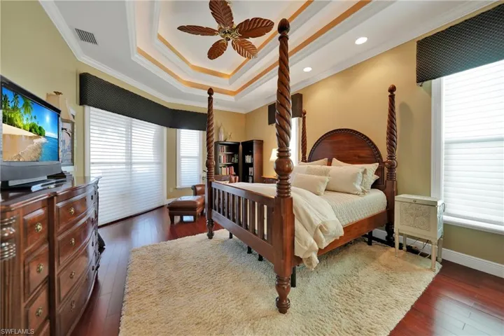 Bedroom with ceiling fan, crown molding, and dark hardwood / wood-style floors