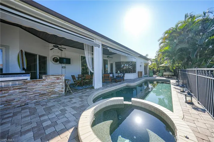 View of pool with exterior bar, ceiling fan, a patio, and an in ground hot tub