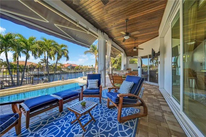 View of patio with a fenced in pool, ceiling fan, and a water view