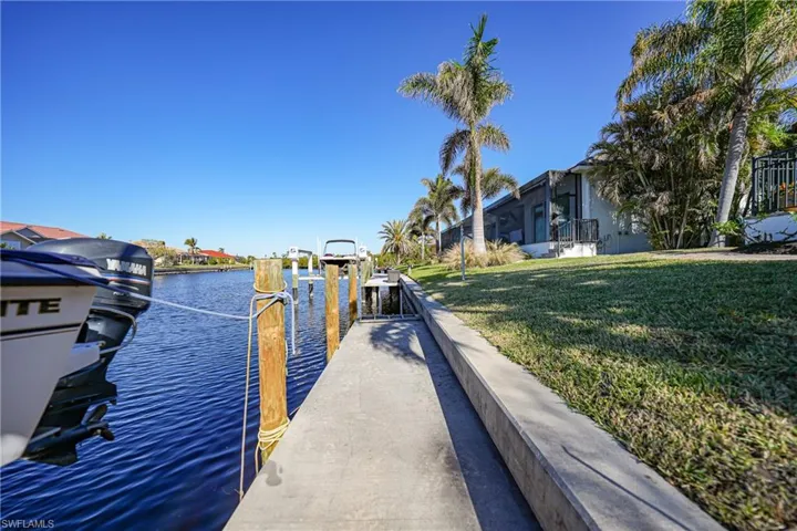 Dock area with a lawn and a water view