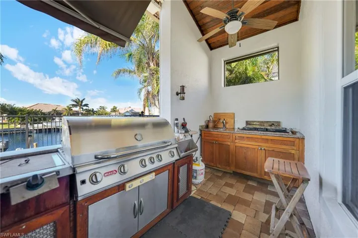 View of patio / terrace with area for grilling, a water view, and exterior kitchen
