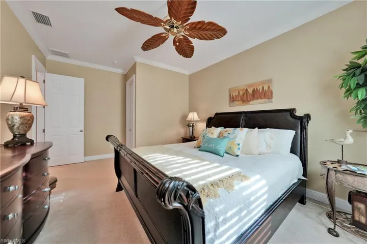 Bedroom featuring ceiling fan, crown molding, and light carpet