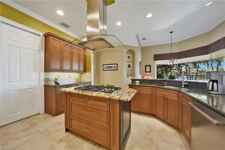 Kitchen featuring island exhaust hood, ornamental molding, sink, and appliances with stainless steel finishes