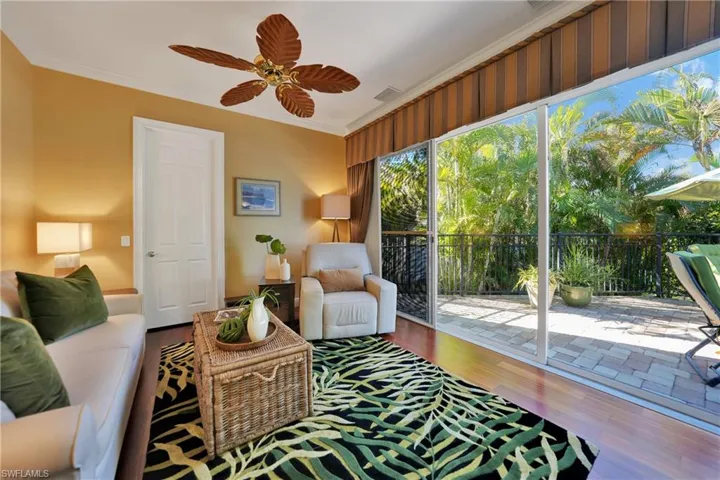 Living room with crown molding, ceiling fan, and hardwood / wood-style flooring
