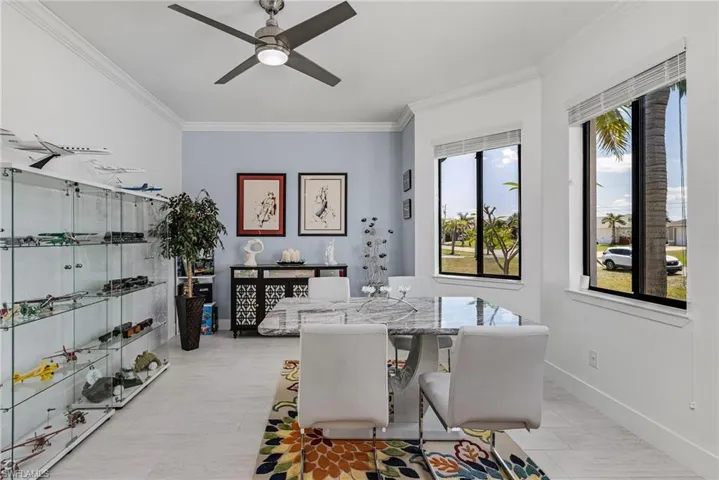 Dining space with a ceiling fan, baseboards, and ornamental molding