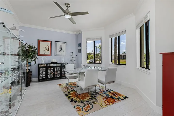 Dining room featuring a ceiling fan, baseboards, and ornamental molding