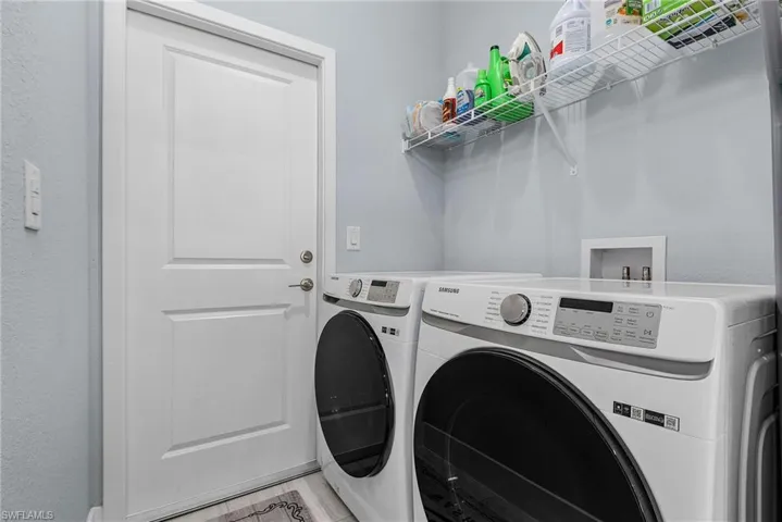 Clothes washing area featuring light wood finished floors, washer and dryer, and laundry area