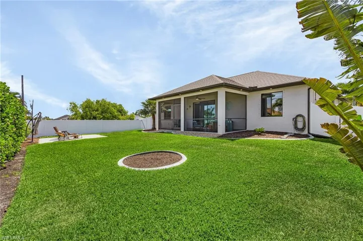 Back of house with a ceiling fan, a fenced backyard, a yard, stucco siding, and a sunroom