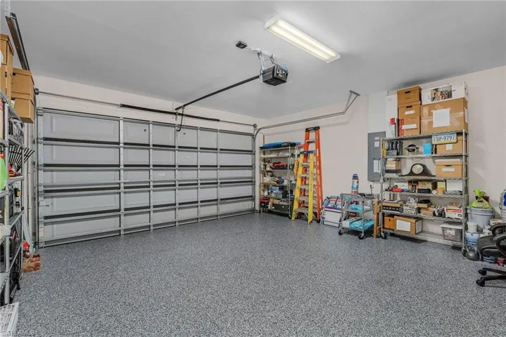 Garage featuring electric panel and a garage door opener