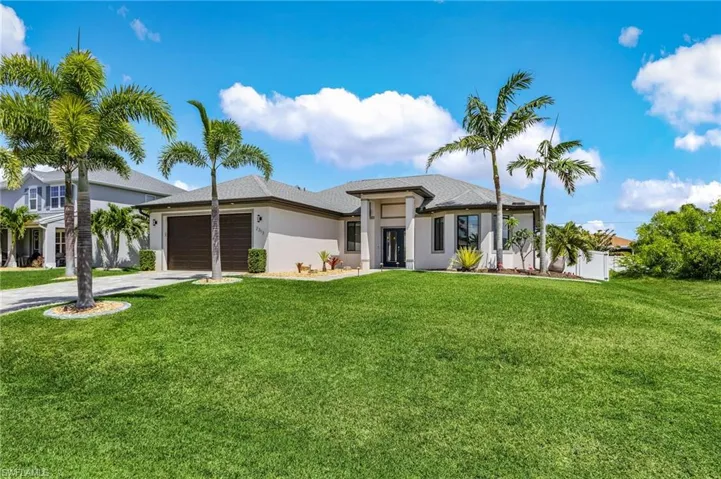 Prairie-style home with concrete driveway, an attached garage, a front lawn, and stucco siding