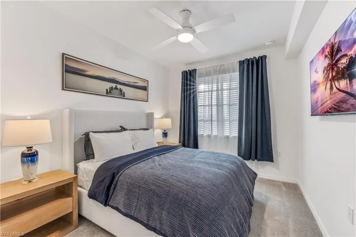 Carpeted bedroom featuring ceiling fan
