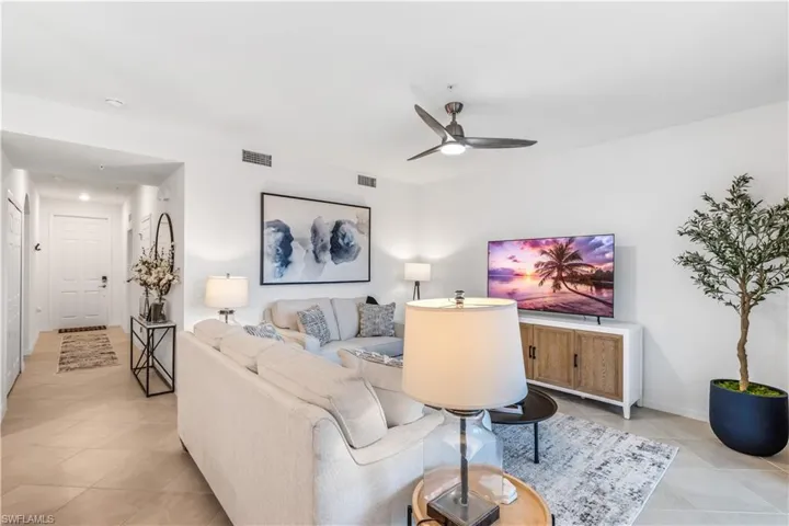 Living room featuring light tile patterned floors and ceiling fan