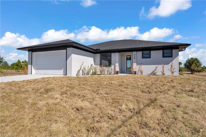 View of front facade featuring stucco siding, a front lawn, and driveway