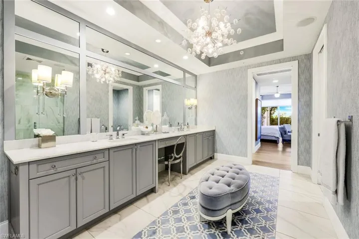 Two sinks, a separate vanity, custom wallpaper and lighting - this is a stunning space!