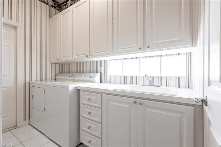 Spacious laundry room with plenty of storage cabinets.