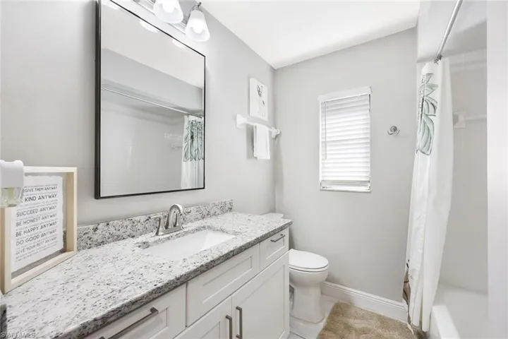 Full bathroom featuring vanity, toilet, and shower / bath combo with shower curtain