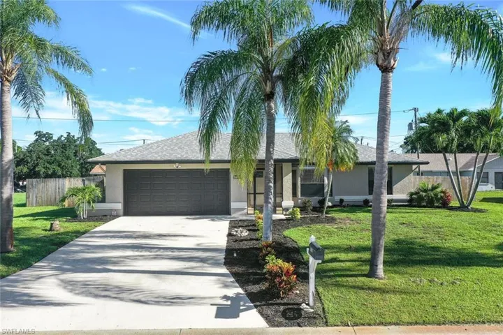 Ranch-style house featuring a garage and a front yard