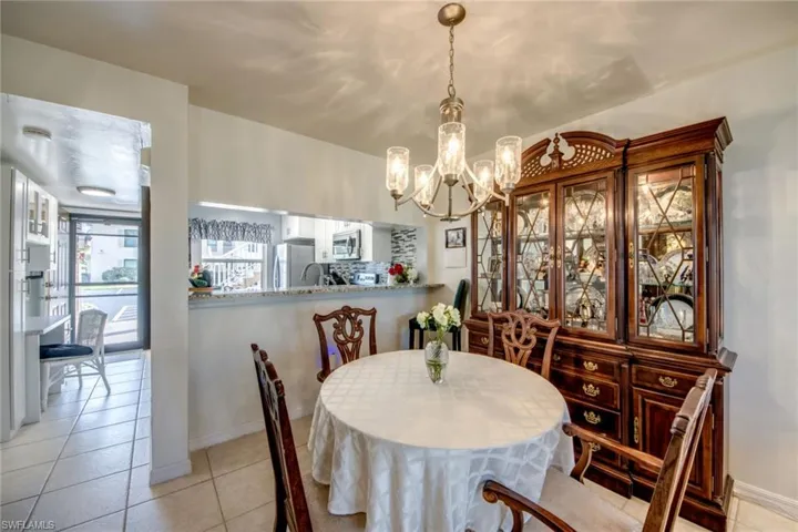Inviting dining space featuring baseboards, an inviting chandelier, and looking into kitchen