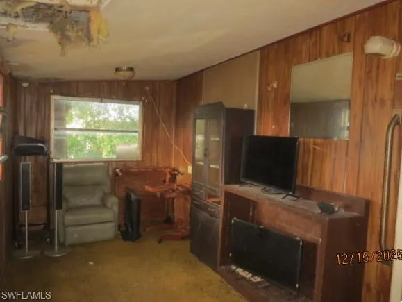 Enclosed front porch with wood walls and carpet
