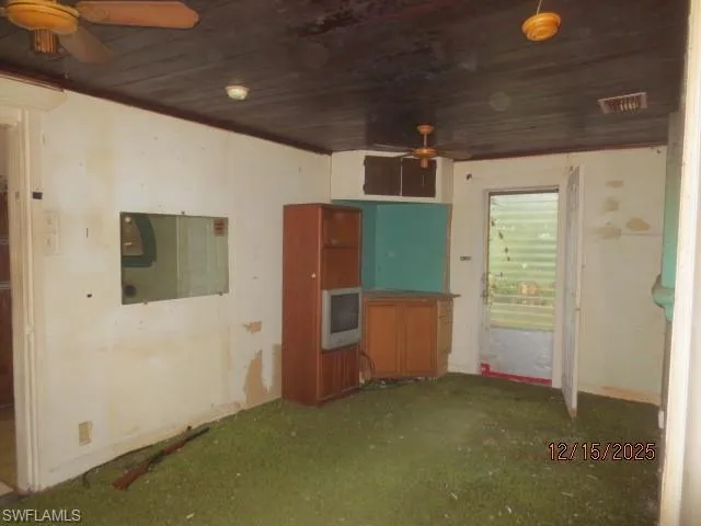 Spare room featuring ceiling fan, wood ceiling, and carpet