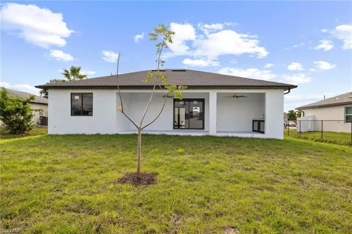 Rear view of property with ceiling fan, stucco siding, a patio, and a shingled roof