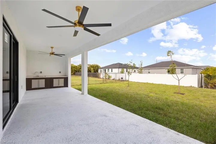 Fenced backyard with a patio and ceiling fan