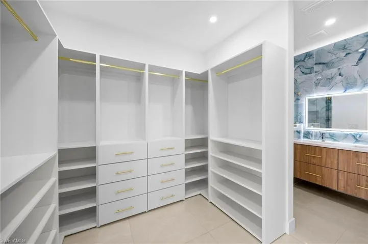 Spacious closet with light tile patterned flooring and a sink