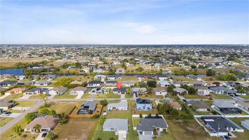 Aerial view of property and surrounding area with nearby suburban area and a large body of water