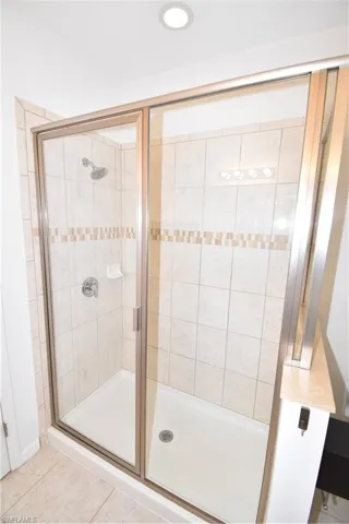 Full bathroom with a shower stall and light tile patterned floors