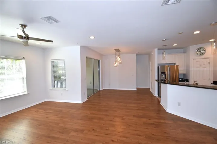 Unfurnished living room featuring dark wood-type flooring, a ceiling fan, and recessed lighting