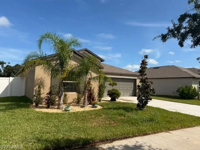 View of front facade featuring concrete driveway, stucco siding, and an attached garage