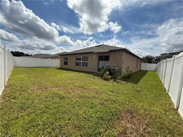 Back of property featuring a fenced backyard and stucco siding