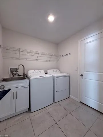Washroom featuring light tile patterned floors and washer and dryer