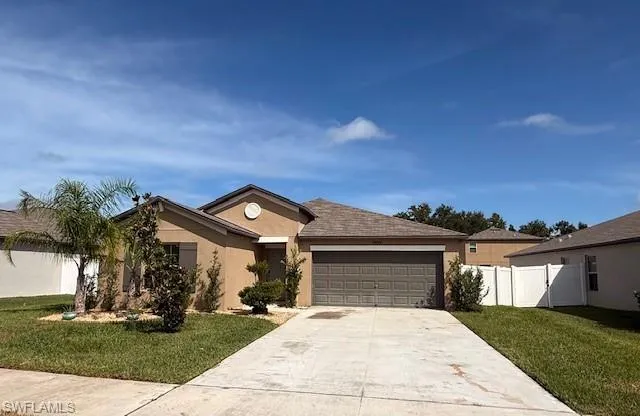 Ranch-style home with a garage, driveway, and stucco siding