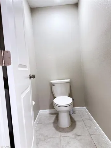 Bathroom with toilet and light tile patterned floors