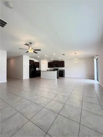 Unfurnished living room with light tile patterned flooring, ceiling fan, recessed lighting, a textured ceiling, and a chandelier