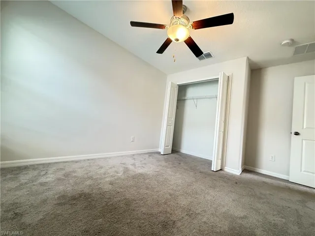 Unfurnished bedroom featuring carpet flooring, a ceiling fan, and a closet