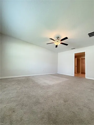 Unfurnished bedroom with carpet, a textured ceiling, and a ceiling fan