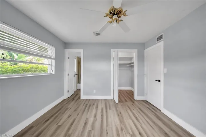 Unfurnished bedroom featuring light wood-type flooring, a walk in closet, and ceiling fan