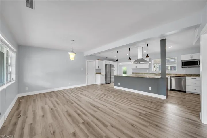 Unfurnished living room featuring baseboards and light wood finished floors