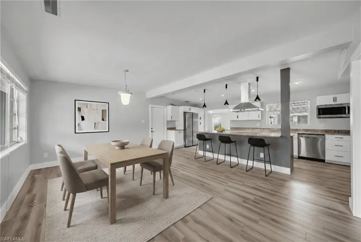 Dining area with light wood-style floors and recessed lighting
