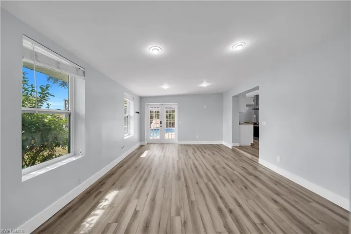 Unfurnished living room featuring french doors and wood finished floors